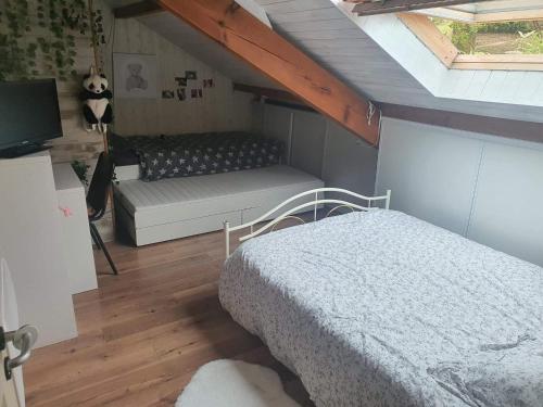 - une chambre mansardée avec un lit et un canapé dans l'établissement Villa avec piscine à proximite de la plage 10 pers, à Ondres
