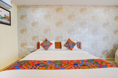 a bedroom with a bed with a colorful quilt on it at FabHotel Partha Residency - Kr puram in Bangalore