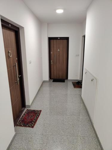 an empty hallway with two doors and a rug at Apartman IDEA Tuzla in Tuzla
