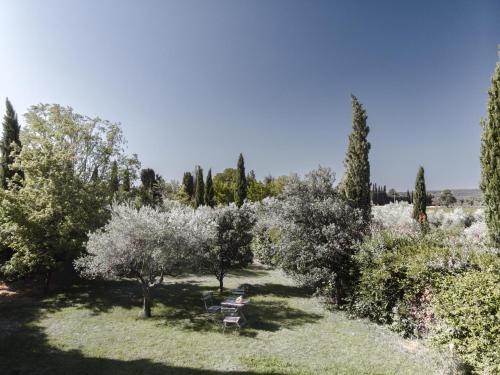 a person sitting on a bench in a garden at Mas des Vignes in Sainte-Cécile-les-Vignes
