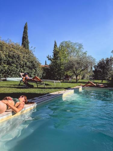 a couple of people laying in a swimming pool at Mas des Vignes in Sainte-Cécile-les-Vignes