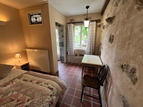 une chambre avec un lit, un bureau et une fenêtre dans l'établissement Gite, à Saint-Maurice-près-Pionsat