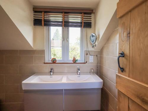 a bathroom with two sinks and a window at Stonegarth Mews in Ambleside