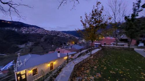 a house with lights on the side of it at night at Αρχοντικό Βαρσάνη ! in Anilio Metsovo