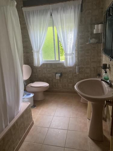 a bathroom with a sink and a toilet and a window at El Rincón de Oriona in Cedeira