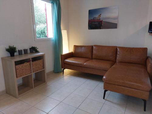 un salon avec un canapé et une chaise dans l'établissement Apartment Les Jardins de l'Océan by Interhome, à Bias