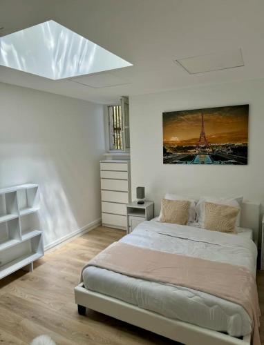 une chambre avec un lit avec un tableau sur le mur dans l'établissement Parisian Spacious 70m2 Flat Near Eiffel Tower, à Paris