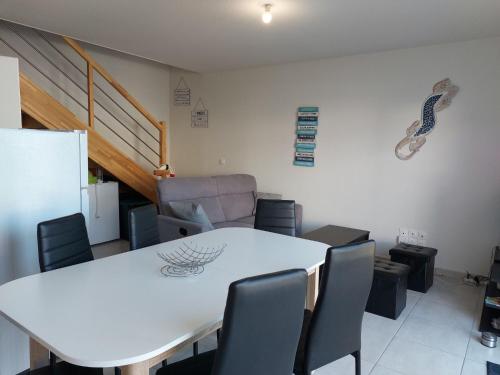 une salle à manger avec une table et des chaises blanches dans l'établissement Apartment SC C06 by Interhome, à Mimizan