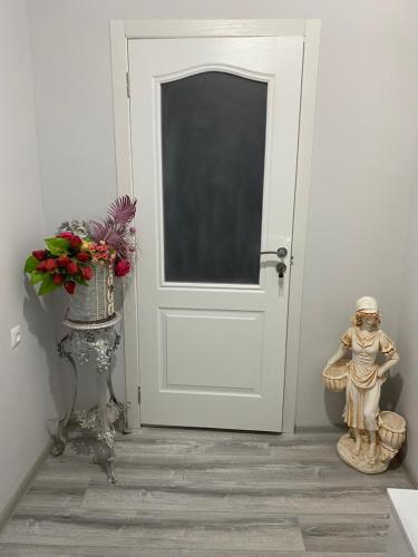 a room with a white door and a vase of flowers at Отдых в Ташире in Vorontsovka