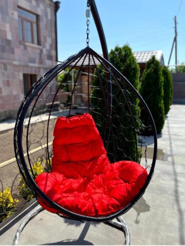 a swing with a red cushion sitting in a swing at Отдых в Ташире in Vorontsovka