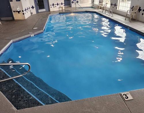 a large pool with blue water in a building at Lighthouse Suites Inn in Ocean Shores