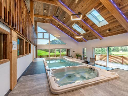 a hot tub in the middle of a room with windows at Apartment Karlspitz by Interhome in Kleinsölk