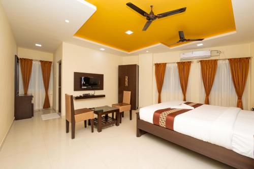 a bedroom with a bed and a desk and a ceiling at Hotel Rifaya in Porto Novo