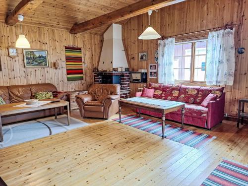 a living room with a couch and a table at Chalet Norrskensstugan by Interhome in Vidsel