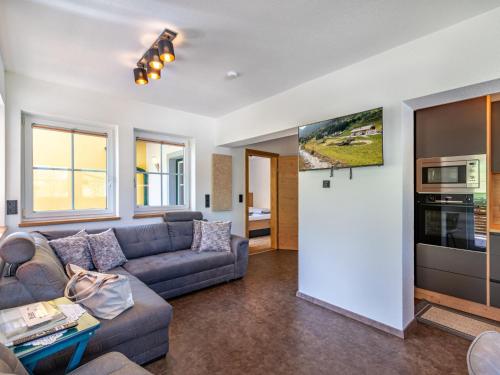 a living room with a couch and a tv at Apartment Grimming by Interhome in Kleinsölk