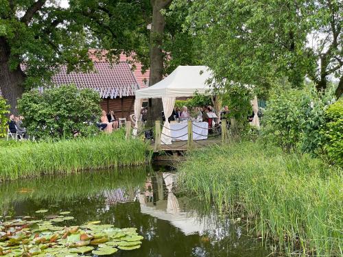 a white tent sitting next to a river with people at Landhaus Bruckmann in Saerbeck
