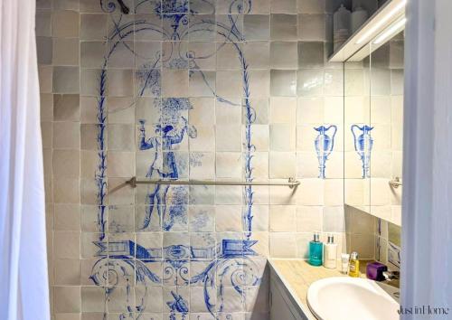 La salle de bains est pourvue de vases en verre bleu sur le mur. dans l'établissement Magnifique appartement, coeur d'Uzès, clim, à Uzès