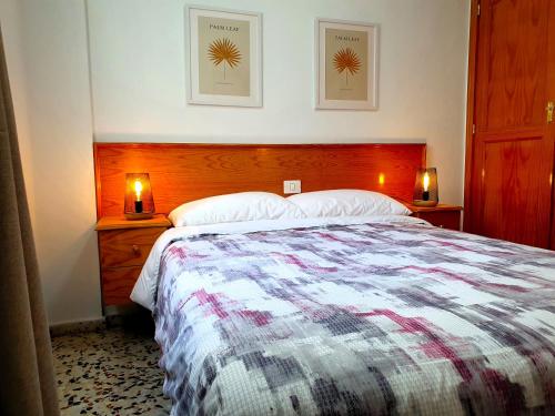 ロス・アブリゴスにあるSeaside Whale Apartments WIFI 1Dのベッドルーム1室(大型ベッド1台、2つの照明付)