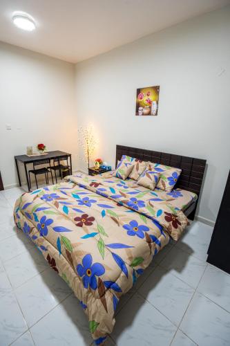 a bedroom with a large bed with blue flowers on it at tourist Peaceful Family Rooms Abu Dhabi ME11APT baith al jannah LLC in Abu Dhabi