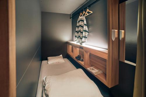 a small room with two beds and a window at UNPLAN Fukuoka in Fukuoka
