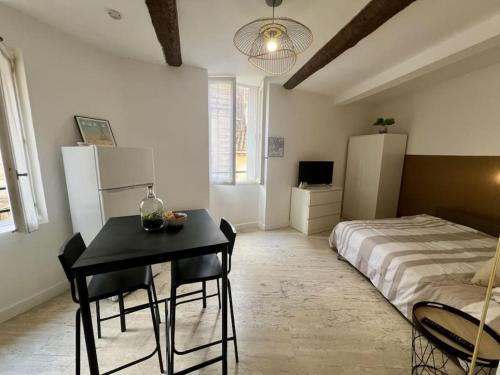 une chambre avec un lit, une table et des chaises dans l'établissement Studio Cozy Cœur de Ville, à Béziers