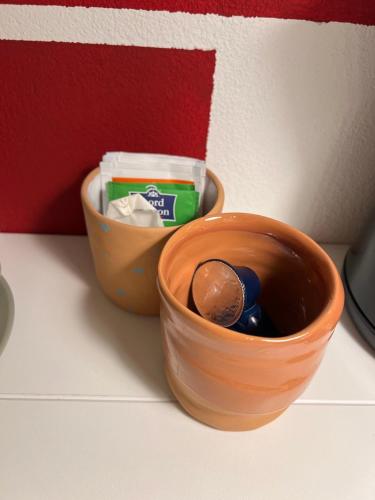 an orange bowl with a ball in it next to a container at La Cascina di Bea in Torre Boldone
