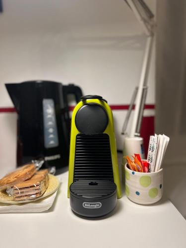 a black and yellow appliance on a counter with a cup of pens at La Cascina di Bea in Torre Boldone