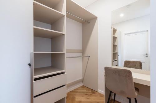 a walk in closet with a desk and a chair at Stylish Simplicity - 1BDR Cozy Stay in Vilnius in Kontverki