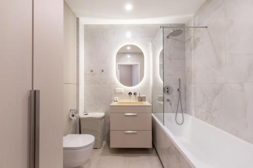 a white bathroom with a tub and a sink and a toilet at Stylish Simplicity - 1BDR Cozy Stay in Vilnius in Kontverki