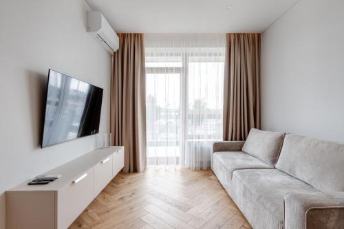 a living room with a couch and a flat screen tv at Stylish Simplicity - 1BDR Cozy Stay in Vilnius in Kontverki