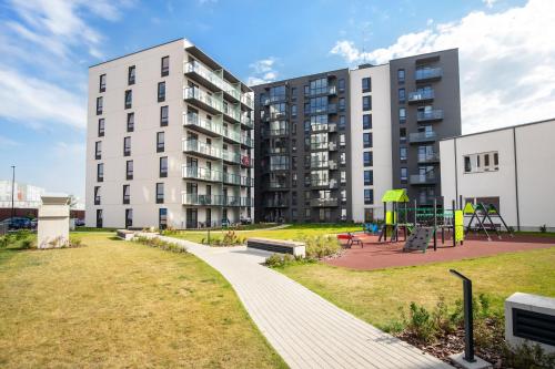 a park in front of a building with a playground at Stylish Simplicity - 1BDR Cozy Stay in Vilnius in Kontverki
