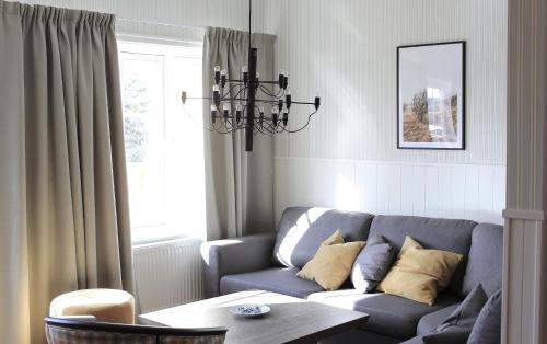 a living room with a blue couch and a chandelier at Gammelgården in  Högfjället