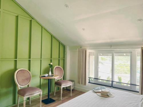a room with two chairs and a table and a window at Beaumont Da Lat Villa in Da Lat