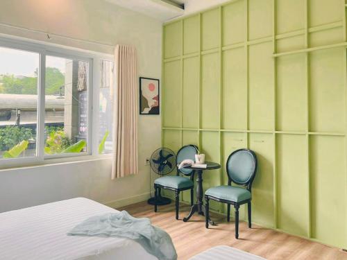 two chairs and a table in a room with green walls at Beaumont Da Lat Villa in Da Lat