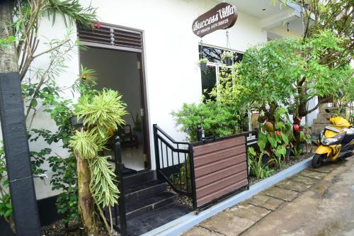 a scooter parked in front of a building with plants at Success Villa Hikkaduwa in Hikkaduwa