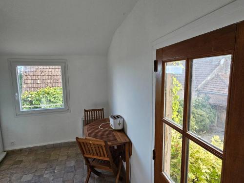Cette chambre dispose d'une table en bois et d'une fenêtre. dans l'établissement Maison unique avec vue sur les vignes, à Baubigny