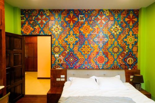 - une chambre avec un lit et un mur coloré dans l'établissement Luxurious large size swimming pool villa in Rawai, à Ban Saiyuan (1)