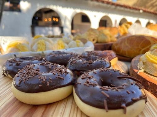 a bunch of chocolate covered donuts on a table at Pousada Puerta Del Sol Rio das Ostras in Rio das Ostras