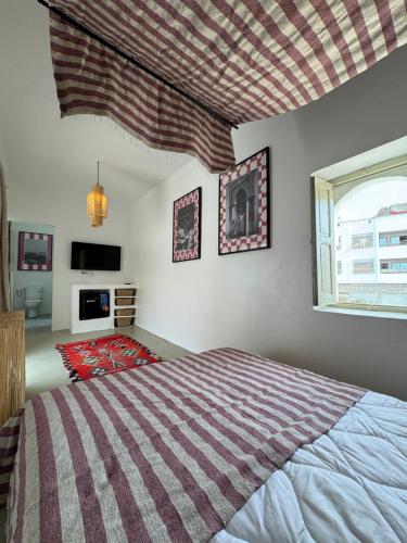 a bedroom with a large bed and a window at Riad Ait El Mouden in Agadir