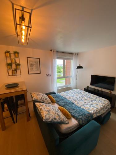 une chambre avec un lit, une table et une fenêtre dans l'établissement Clochette next to Disneyland Paris 5 PAX, à Montévrain