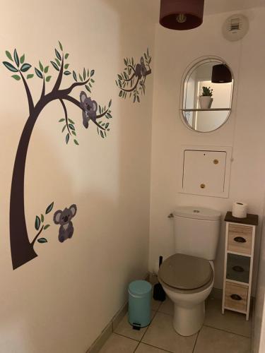 La salle de bains est pourvue de toilettes avec un arbre et des ours en peluche sur le mur. dans l'établissement Clochette next to Disneyland Paris 5 PAX, à Montévrain