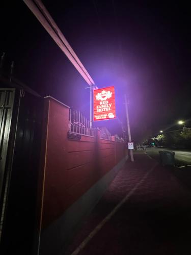 a red sign on a building at night at Red Family Hotel in Vagharshapat