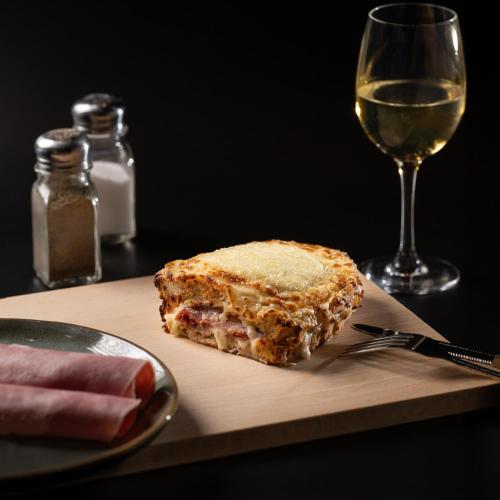a sandwich on a cutting board next to a glass of wine at ibis Bordeaux Centre Bastide in Bordeaux