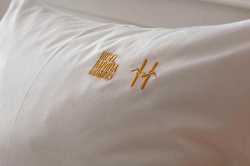 a pair of scissors laying on top of a white pillow at Hotel Gaivota Azores in Ponta Delgada