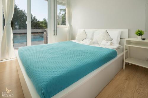 una camera da letto con un letto con una coperta blu di MrBrown Aurelia Residence with Pool a Roma