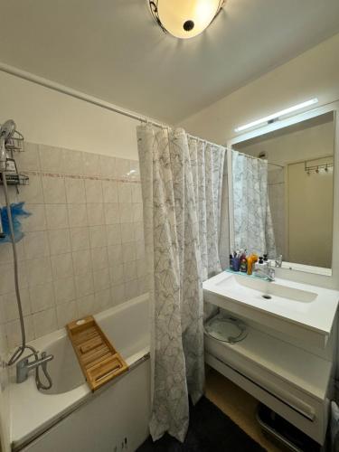 une salle de bain avec un lavabo, une baignoire et un miroir dans l'établissement proche paris la defense, à Clichy