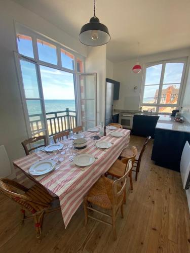 - une table à manger avec des chaises et une vue sur l'océan dans l'établissement Appartement, accès direct plage, vue imprenable face à la mer, à Villers-sur-Mer