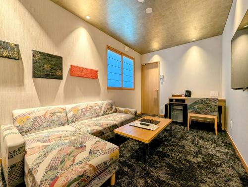 a living room with a couch and a table at ひがし茶屋街らしく金沢 Hotel Rashiku kanazawa in Kanazawa