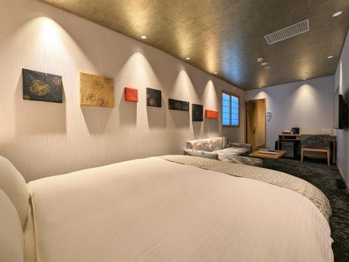 a bedroom with a white bed and a couch at ひがし茶屋街らしく金沢 Hotel Rashiku kanazawa in Kanazawa