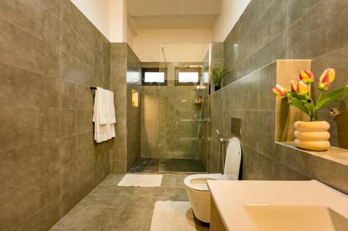 a bathroom with a toilet and a sink and a shower at ThiThi's Palace Mirissa in Mirissa